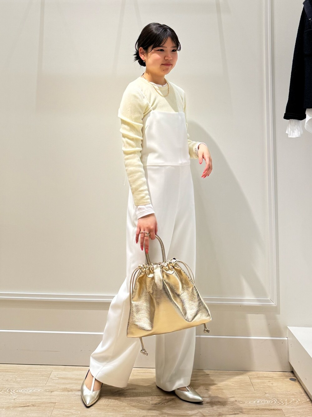 ホワイト系のつなぎ/オールインワン、ゴールド系のショルダーバッグ、ベージュ系のニット/セーターを着用したレディースの春コーディネートの6枚目の写真