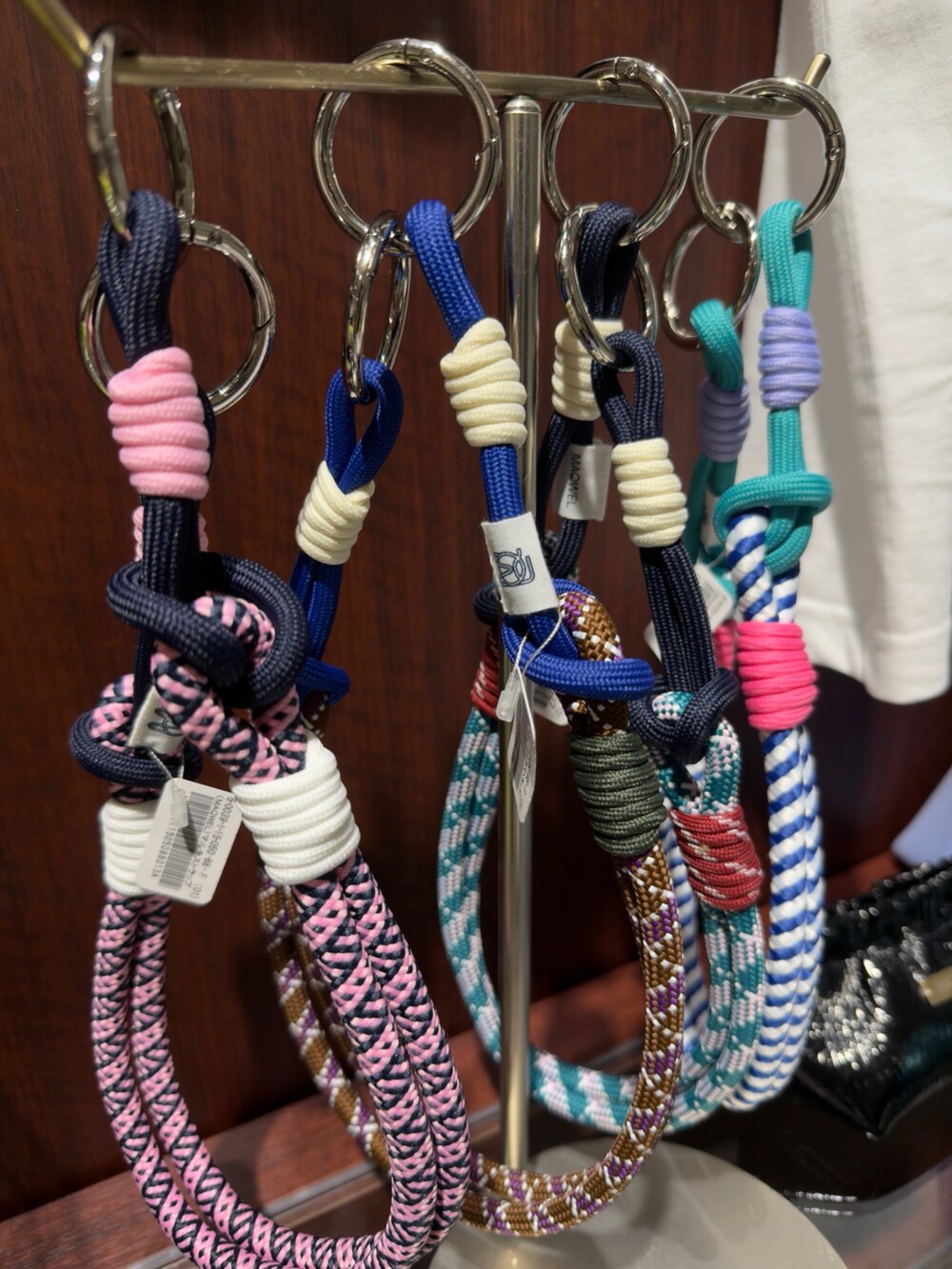 ホワイト系のトートバッグ、ホワイト系のスカート、レッド系のチャームを着用したレディースの夏コーディネートの5枚目の写真
