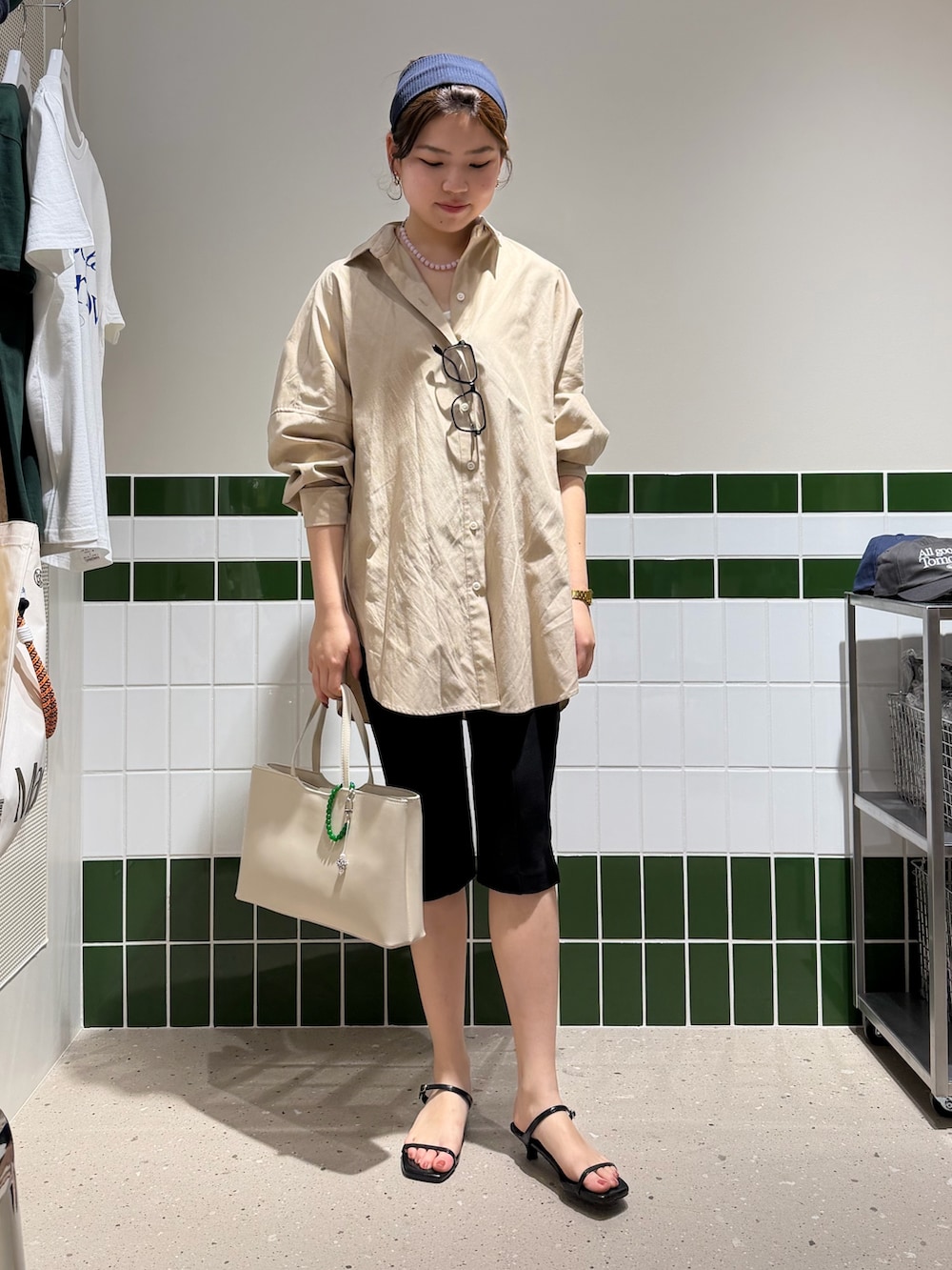 ブラウン系のトートバッグ、ブラック系のその他パンツ、ベージュ系のシャツ/ブラウスを着用したレディースの春コーディネートの2枚目の写真