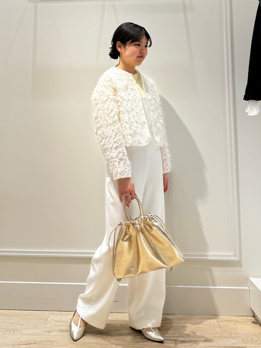 ホワイト系のつなぎ/オールインワン、ゴールド系のショルダーバッグ、ベージュ系のニット/セーターを着用したレディースの春コーディネートの3枚目の写真