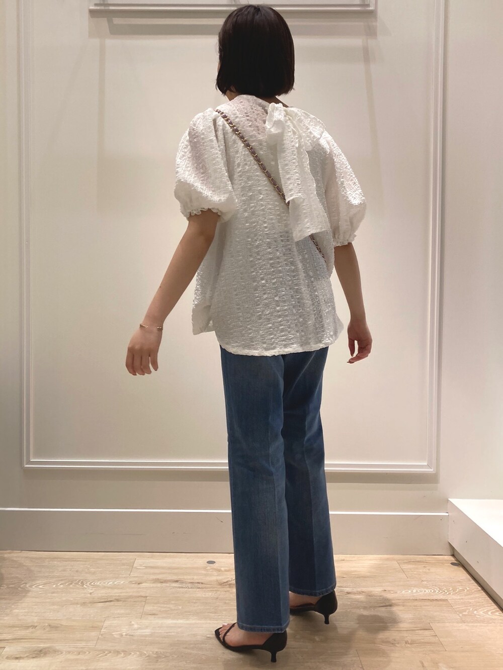 ホワイト系のシャツ/ブラウス、ブラック系のサンダル、パープル系のショルダーバッグを着用したレディースの夏コーディネートの3枚目の写真