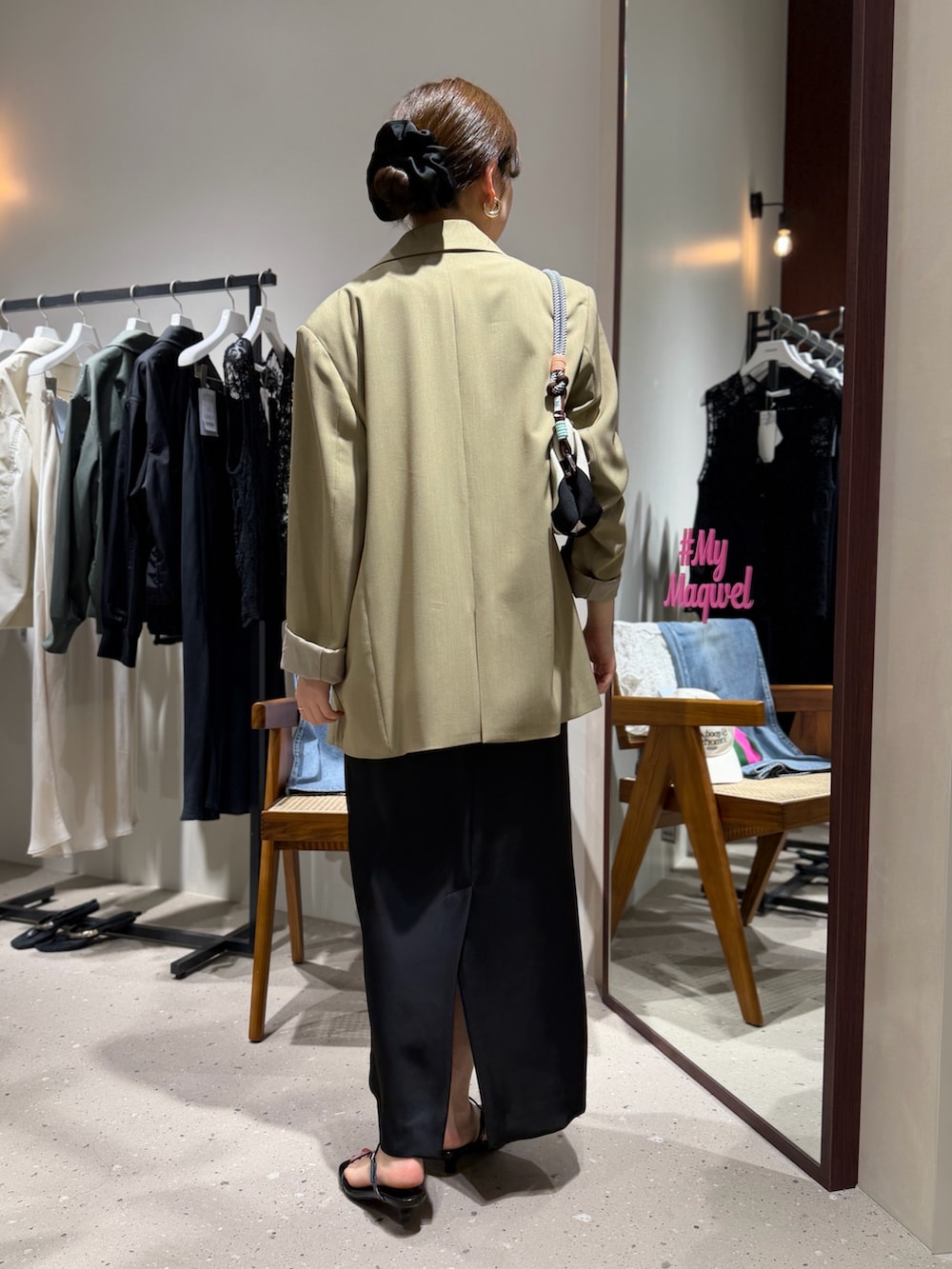 ホワイト系のタンクトップ、ベージュ系のテーラードジャケット、ホワイト系のクラッチバッグを着用したレディースの春コーディネートの2枚目の写真