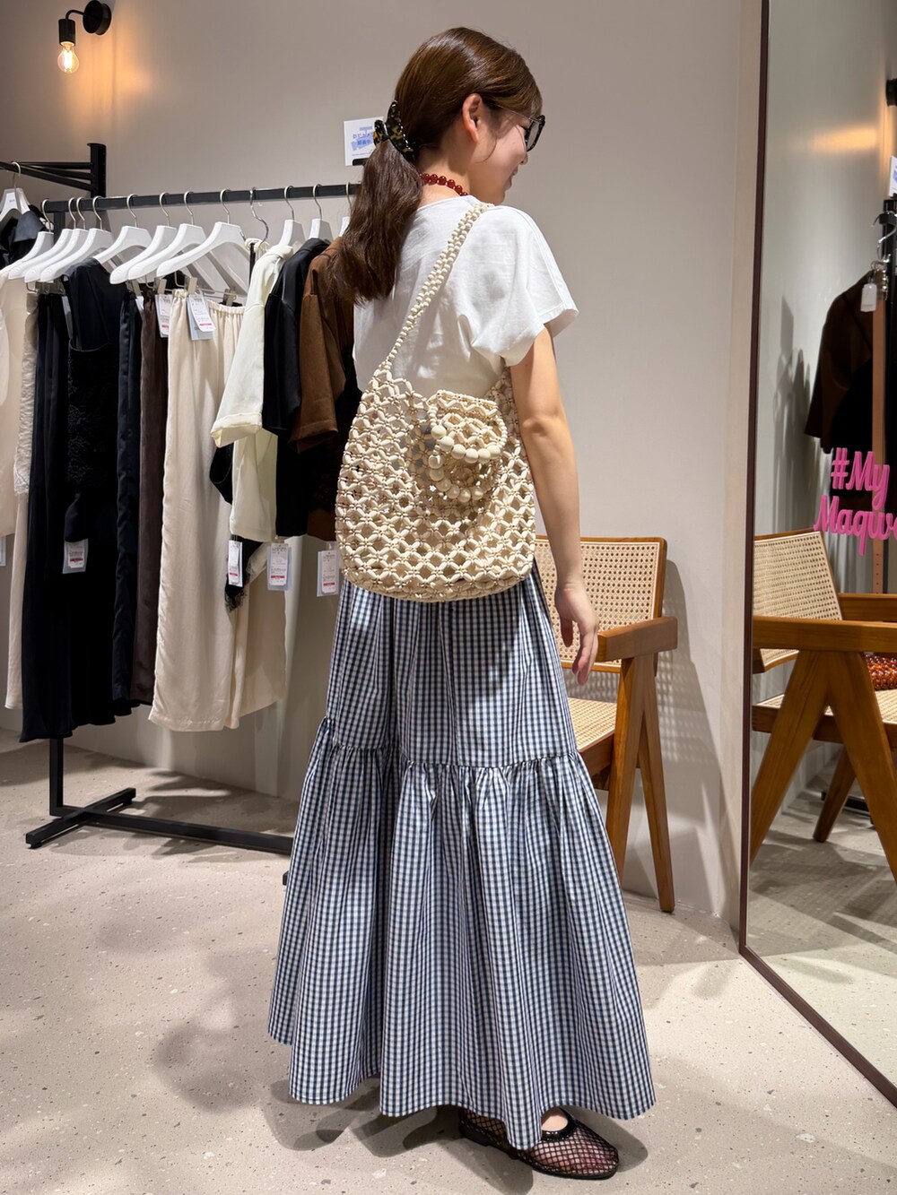 ブルー系のスカート、ホワイト系のTシャツ/カットソー、ブラック系のメガネを着用したレディースの夏コーディネートの4枚目の写真