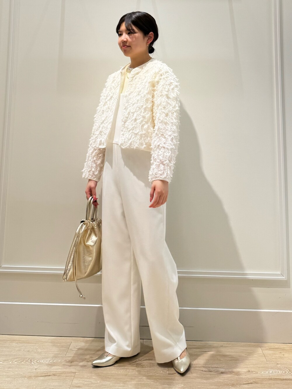 ホワイト系のつなぎ/オールインワン、ゴールド系のショルダーバッグ、ベージュ系のニット/セーターを着用したレディースの春コーディネートの2枚目の写真