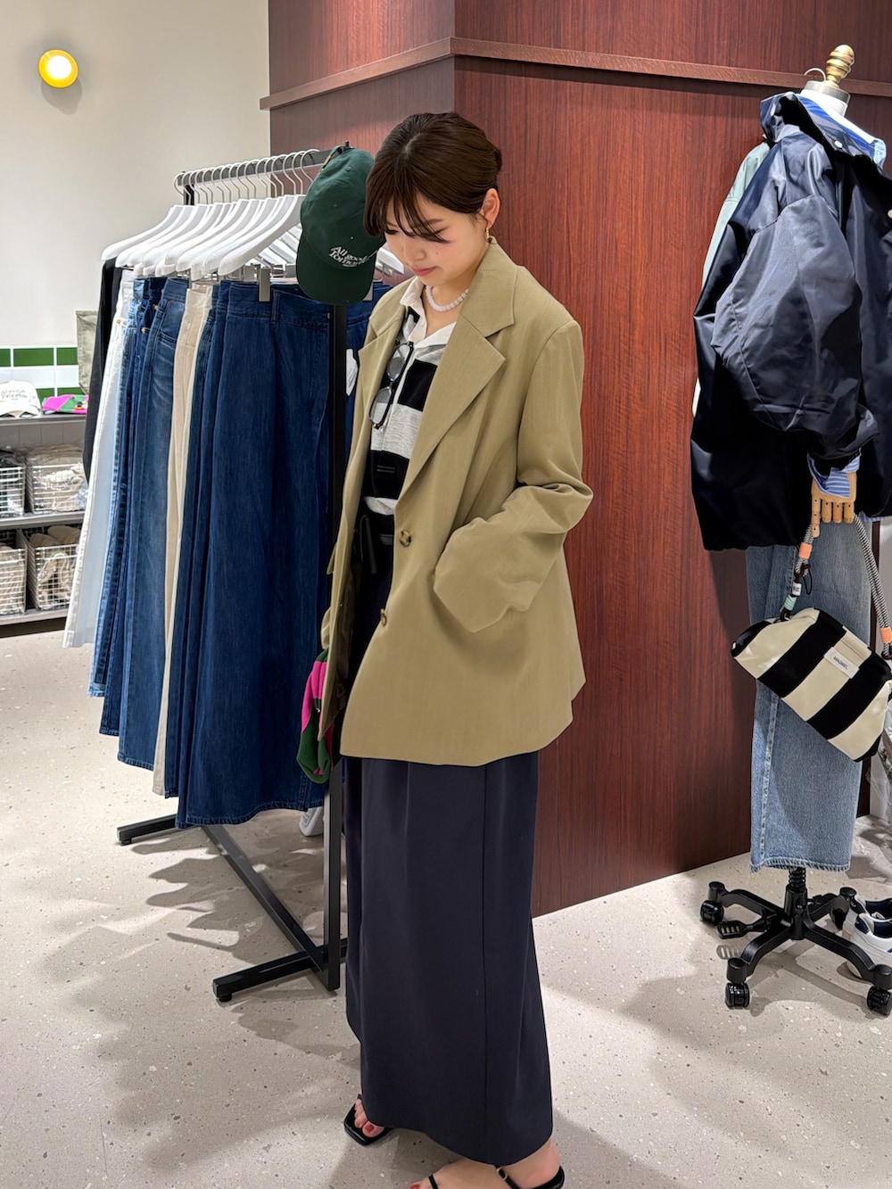 グレー系のシャツ/ブラウス、ブルー系のスカート、ベージュ系のテーラードジャケットを着用したレディースの春コーディネートの3枚目の写真