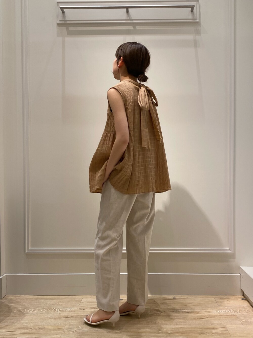 イエロー系のシャツ/ブラウス、ベージュ系のその他パンツ、ホワイト系のショルダーバッグを着用したレディースの夏コーディネートの3枚目の写真