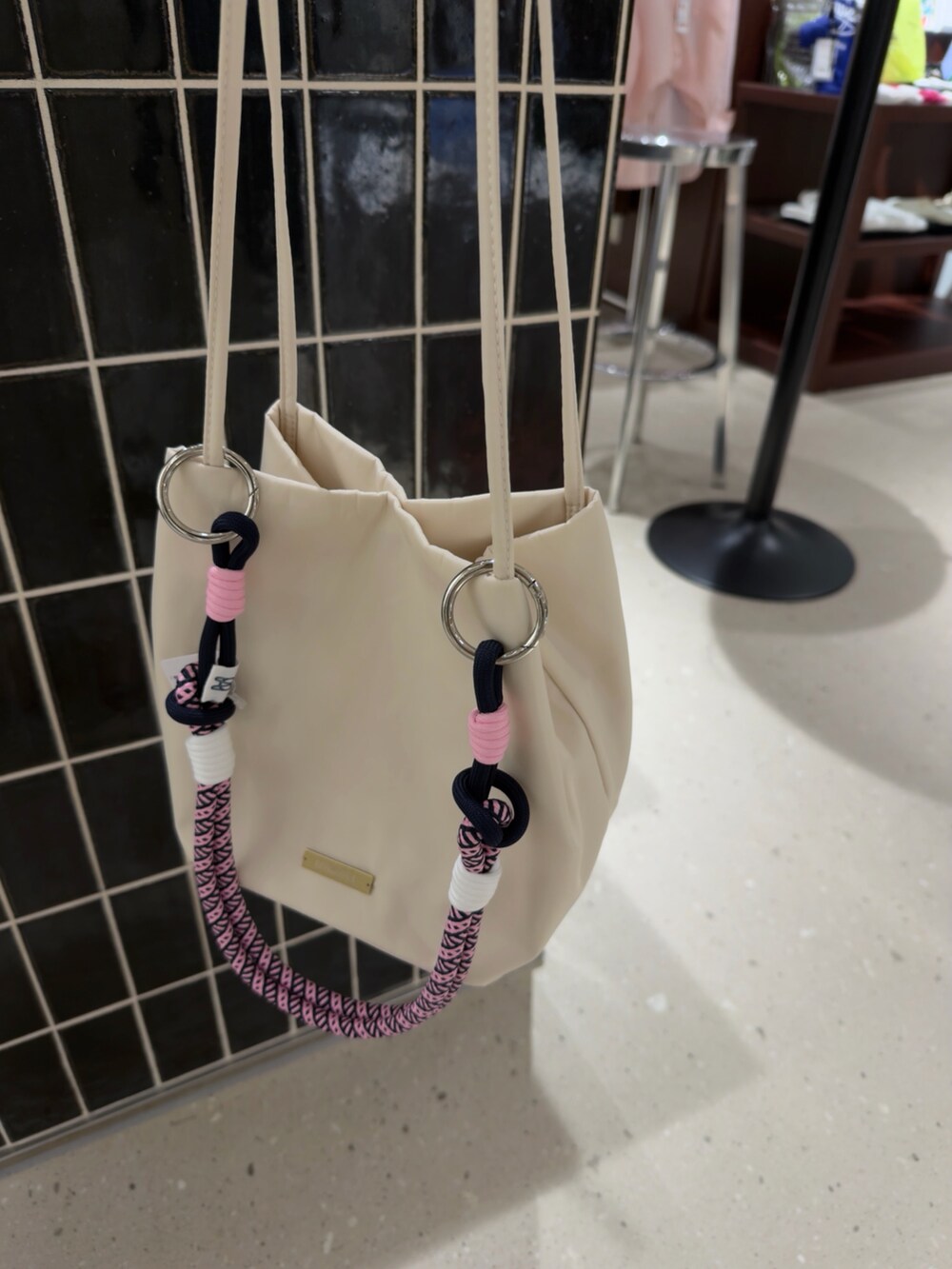 ホワイト系のトートバッグ、ホワイト系のスカート、レッド系のチャームを着用したレディースの夏コーディネートの2枚目の写真