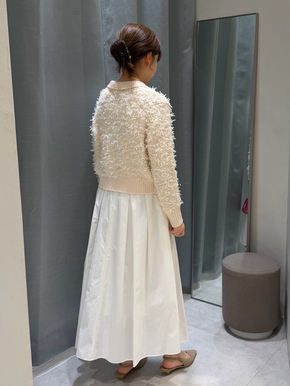 ベージュ系のカーディガン/ボレロ、ホワイト系のスカート、ピンク系のショルダーバッグを着用したレディースの冬コーディネートの2枚目の写真