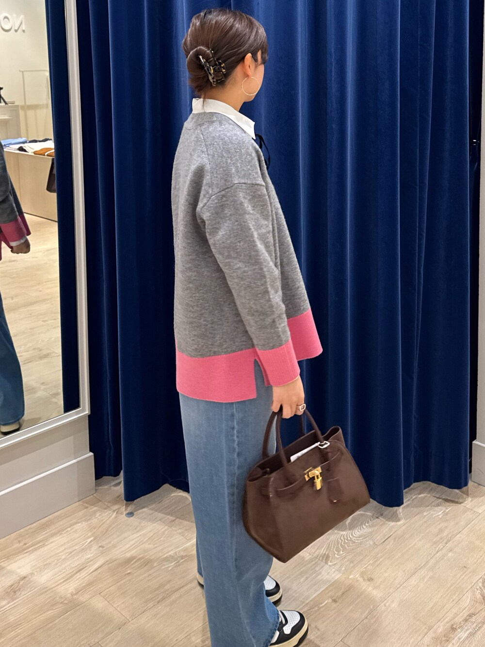 グレー系のカーディガン/ボレロ、ホワイト系のシャツ/ブラウス、ブルー系のデニムパンツを着用したレディースの秋コーディネートの4枚目の写真