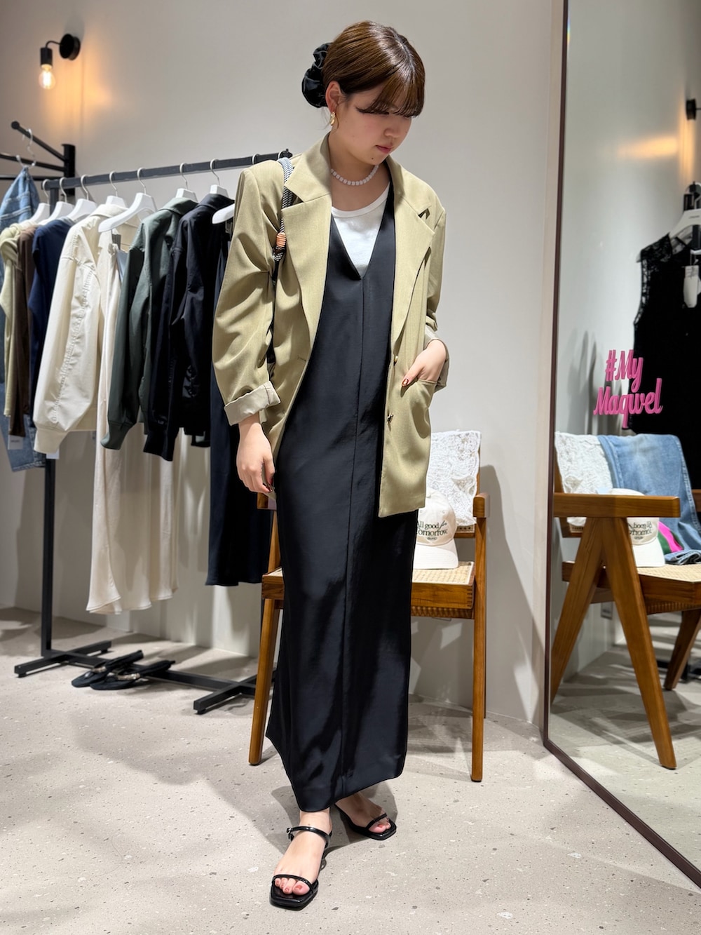 ホワイト系のタンクトップ、ベージュ系のテーラードジャケット、ホワイト系のクラッチバッグを着用したレディースの春コーディネートの3枚目の写真