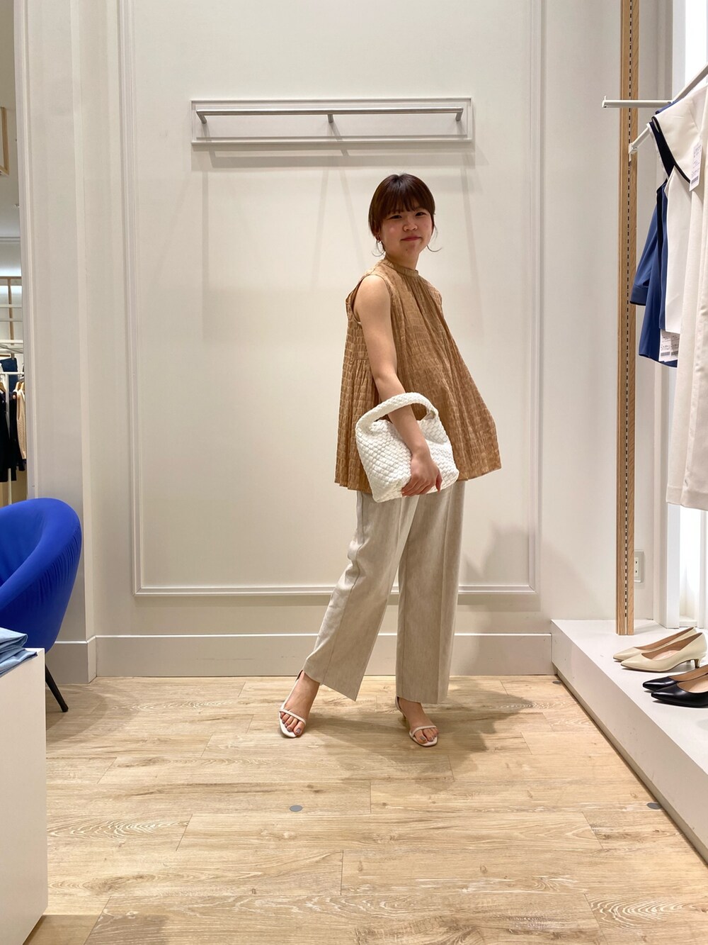 イエロー系のシャツ/ブラウス、ベージュ系のその他パンツ、ホワイト系のショルダーバッグを着用したレディースの夏コーディネートの2枚目の写真