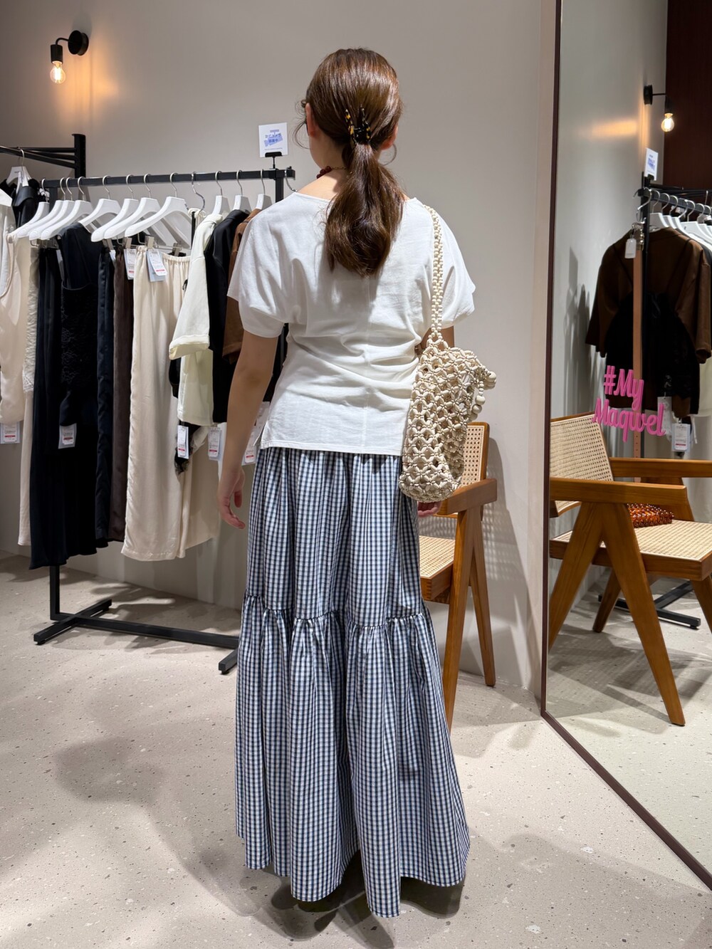 ブルー系のスカート、ホワイト系のTシャツ/カットソー、ブラック系のメガネを着用したレディースの夏コーディネートの3枚目の写真