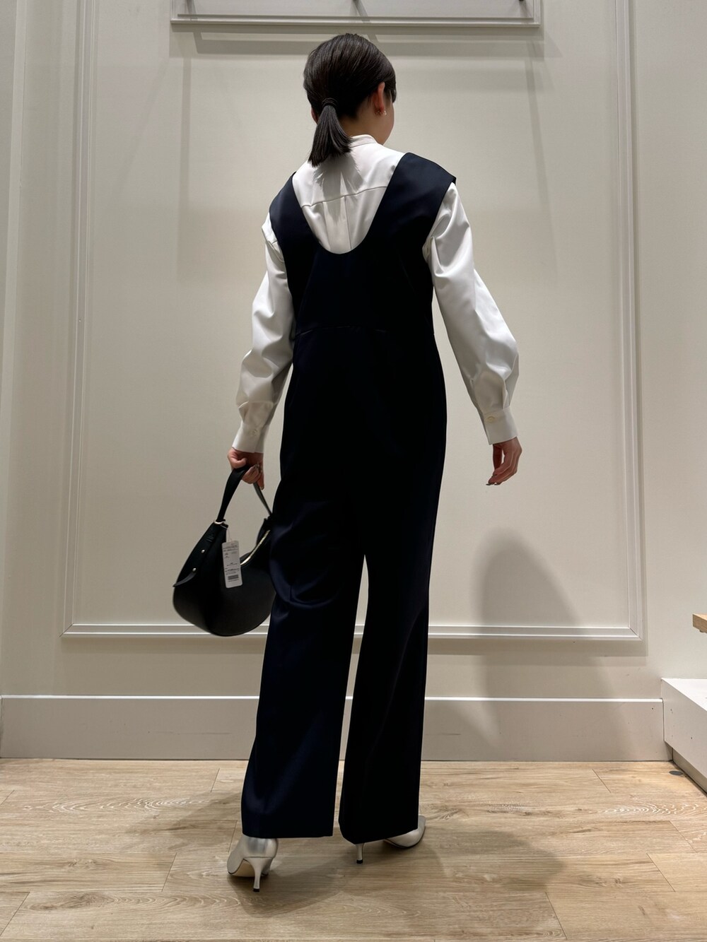 ブルー系のつなぎ/オールインワン、ホワイト系のシャツ/ブラウス、シルバー系のパンプスを着用したレディースの冬コーディネートの5枚目の写真