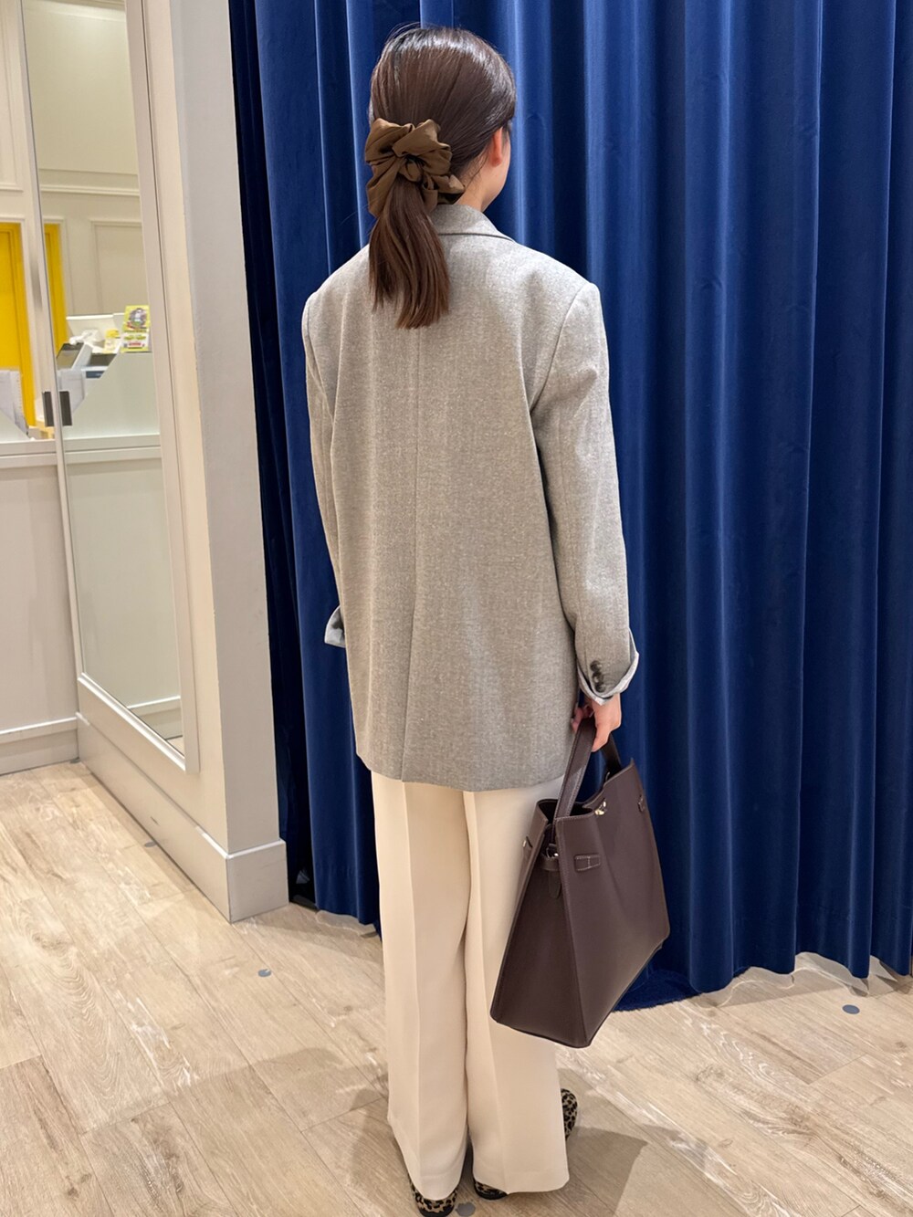 ベージュ系のテーラードジャケット、ブラック系のニット/セーター、ホワイト系のその他パンツを着用したレディースの秋コーディネートの3枚目の写真