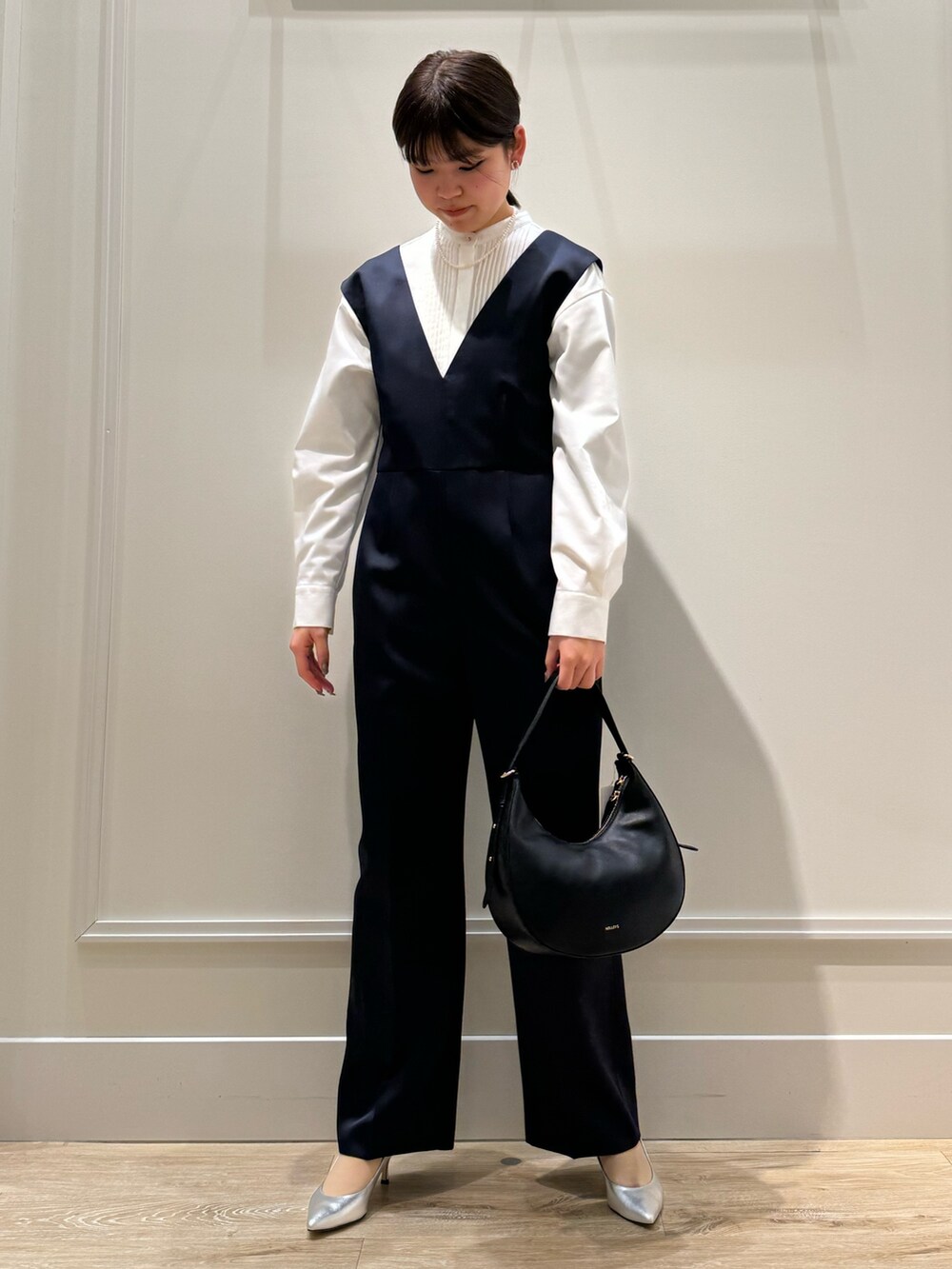 ブルー系のつなぎ/オールインワン、ホワイト系のシャツ/ブラウス、シルバー系のパンプスを着用したレディースの冬コーディネートの7枚目の写真