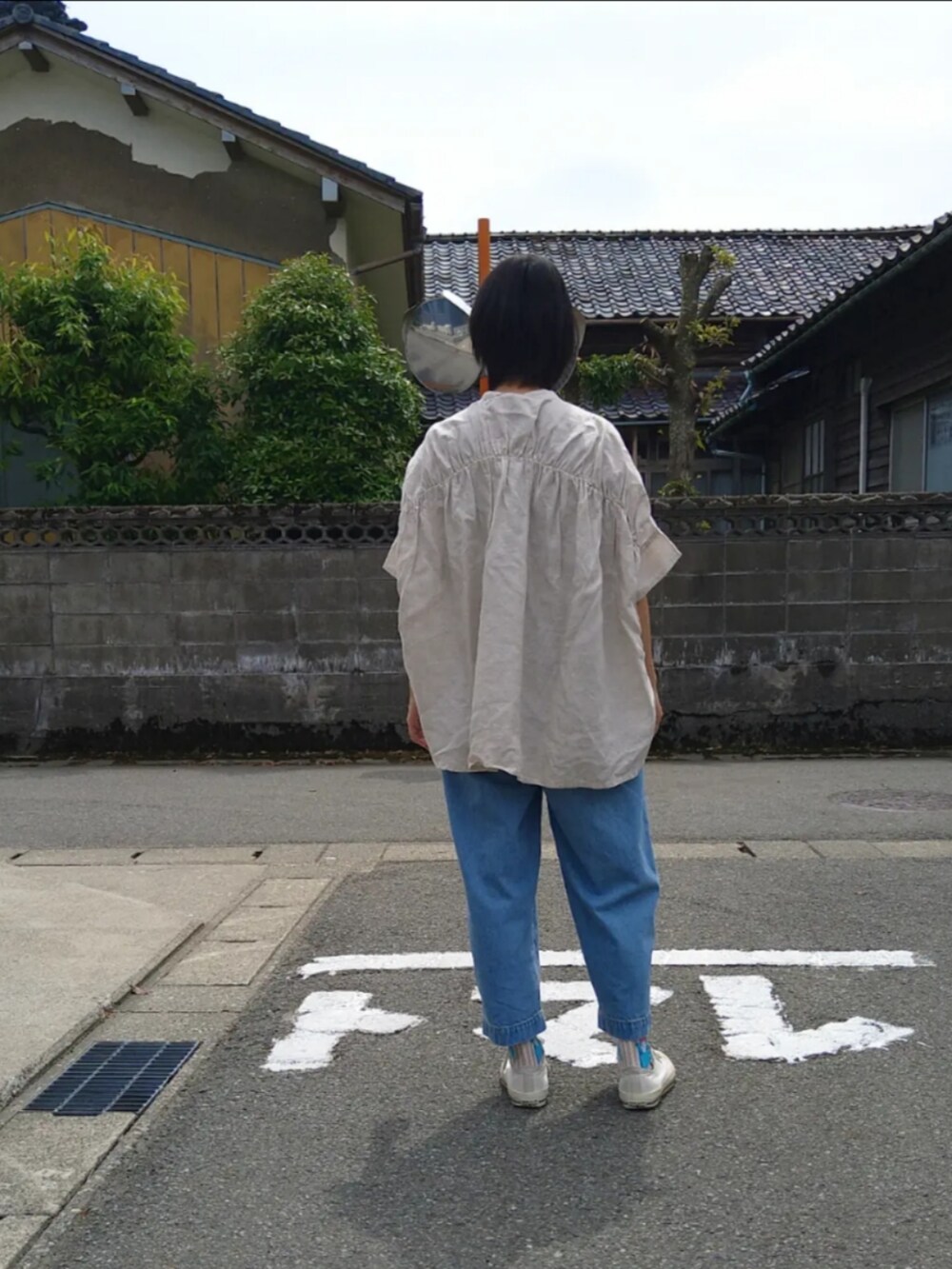 ブルー系のデニムパンツ、ベージュ系のシャツ/ブラウスを着用したレディースの夏コーディネートの2枚目の写真