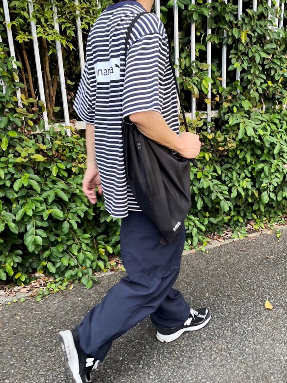 ブラック系のスニーカー、ブラック系のバッグ、ブルー系のカーゴパンツを着用したメンズの秋コーディネートの2枚目の写真