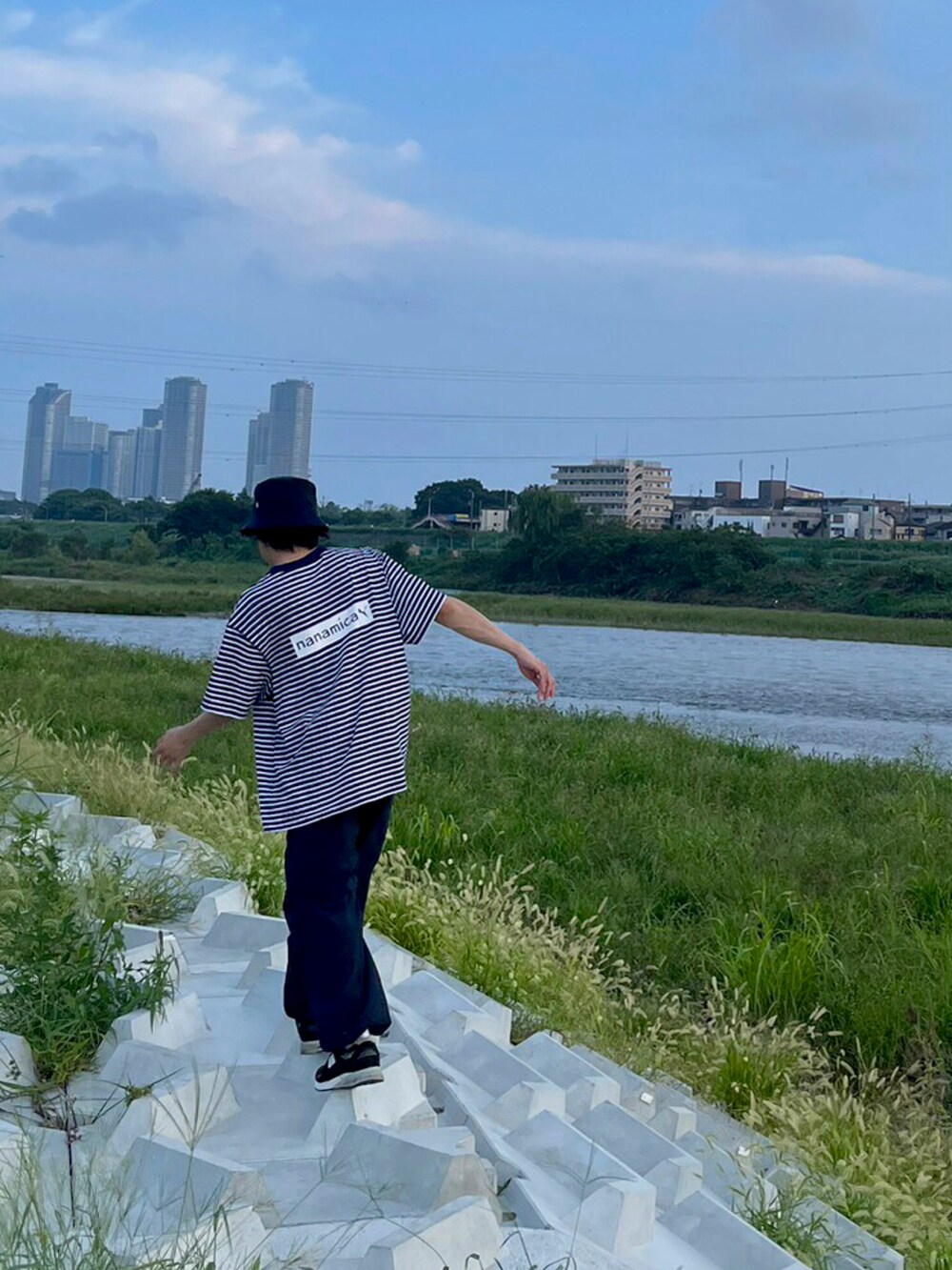 ブラック系のスニーカー、ブラック系のバッグ、ブルー系のカーゴパンツを着用したメンズの秋コーディネートの3枚目の写真