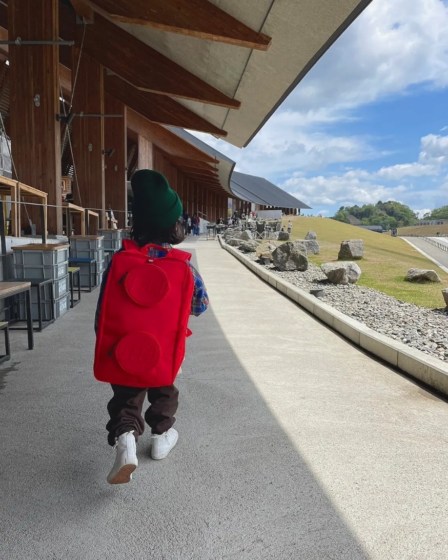 ブラウン系のパンツ、その他のシャツ/ブラウス、レッド系のバックパック/リュックを着用したキッズの春コーディネートの3枚目の写真