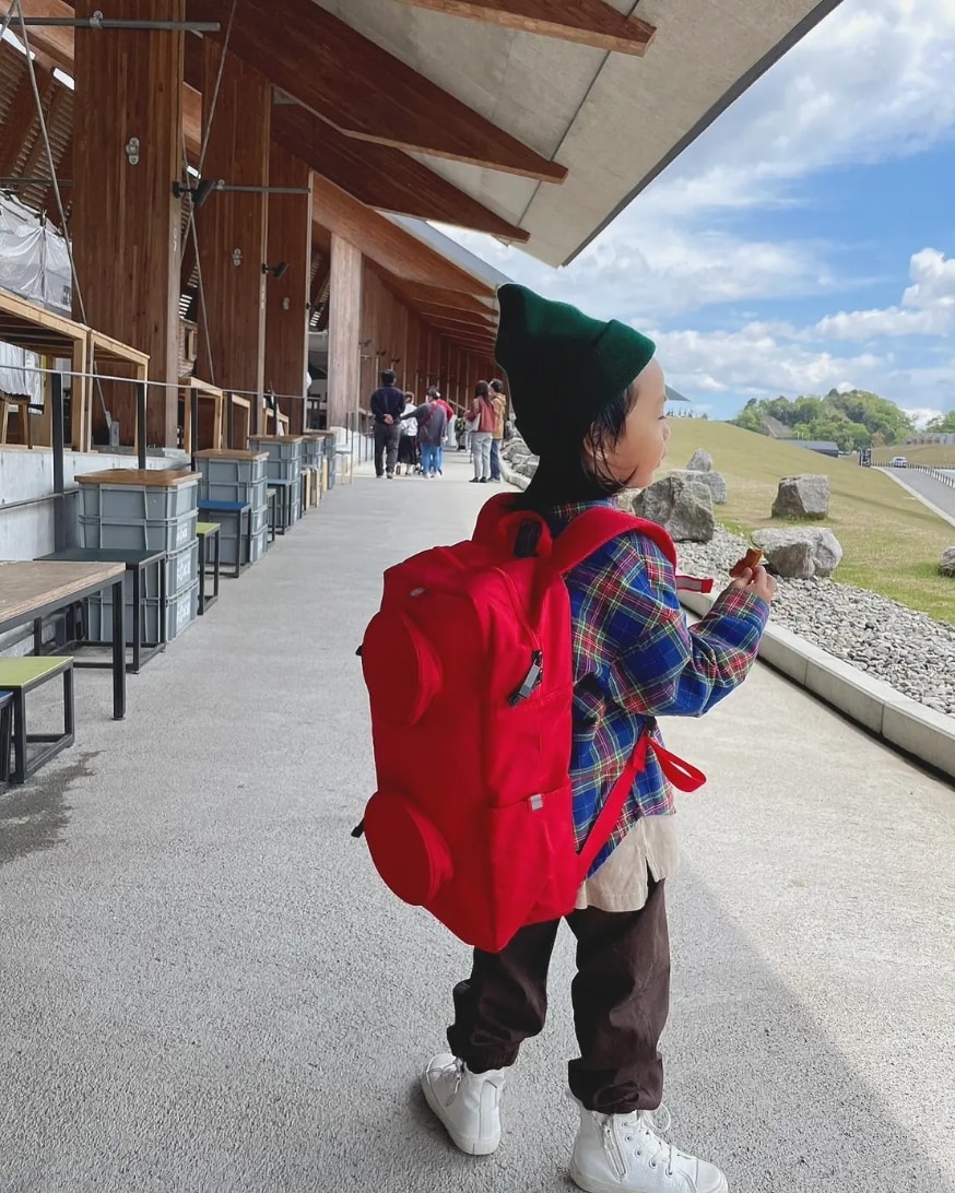 ブラウン系のパンツ、その他のシャツ/ブラウス、レッド系のバックパック/リュックを着用したキッズの春コーディネートの2枚目の写真