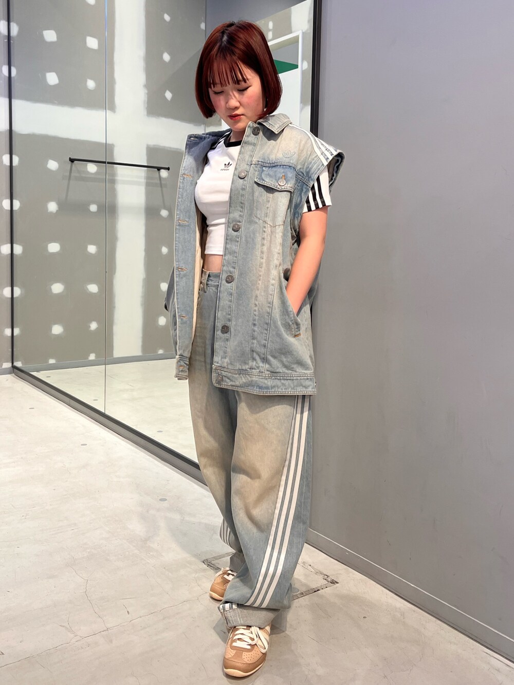 ホワイト系のTシャツ/カットソー、ブルー系のデニムジャケット、ブラウン系のスニーカーを着用したレディースの冬コーディネートの2枚目の写真
