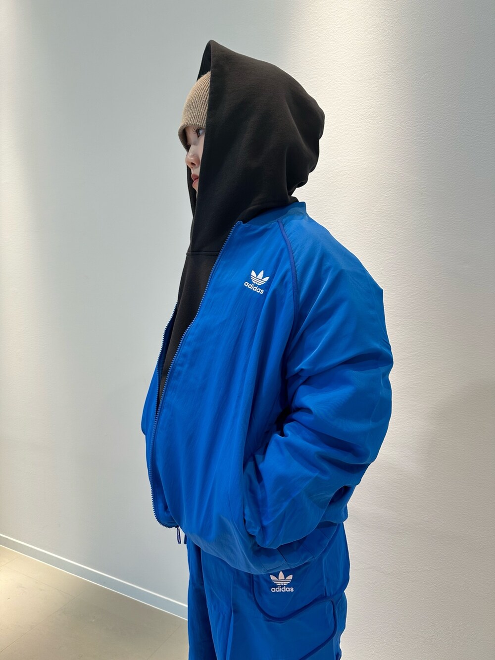 ブルー系のその他パンツ、ブルー系のナイロンジャケット、ブラック系のスニーカーを着用したレディースの冬コーディネートの2枚目の写真