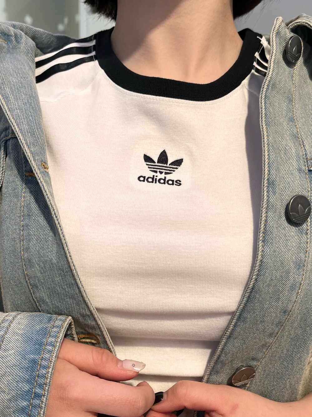 ホワイト系のTシャツ/カットソー、ブルー系のデニムジャケット、ブラウン系のスニーカーを着用したレディースの冬コーディネートの3枚目の写真