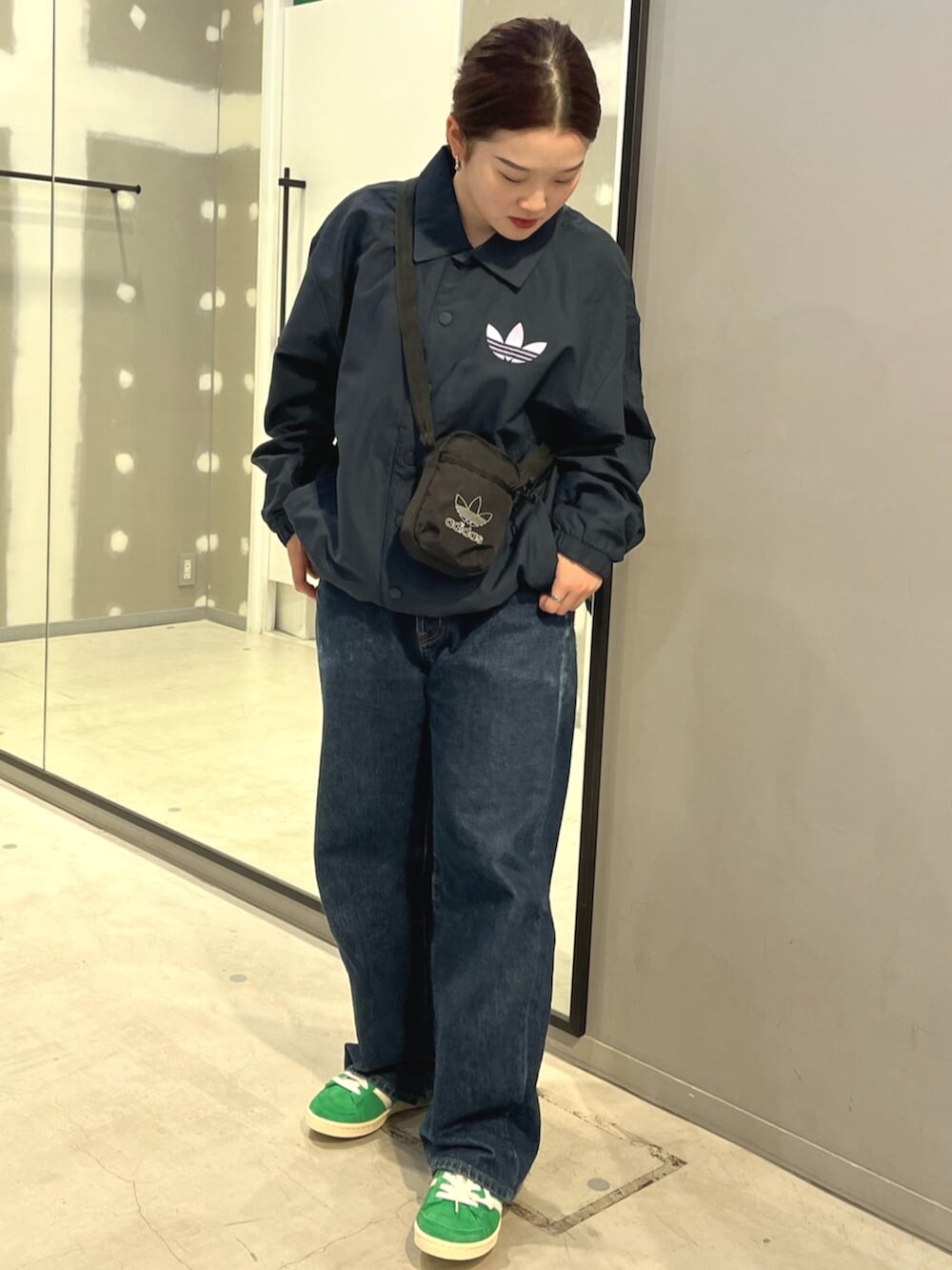 ブルー系のジャケット/アウター、ブラック系のショルダーバッグ、グリーン系のスニーカーを着用したレディースの冬コーディネートの2枚目の写真