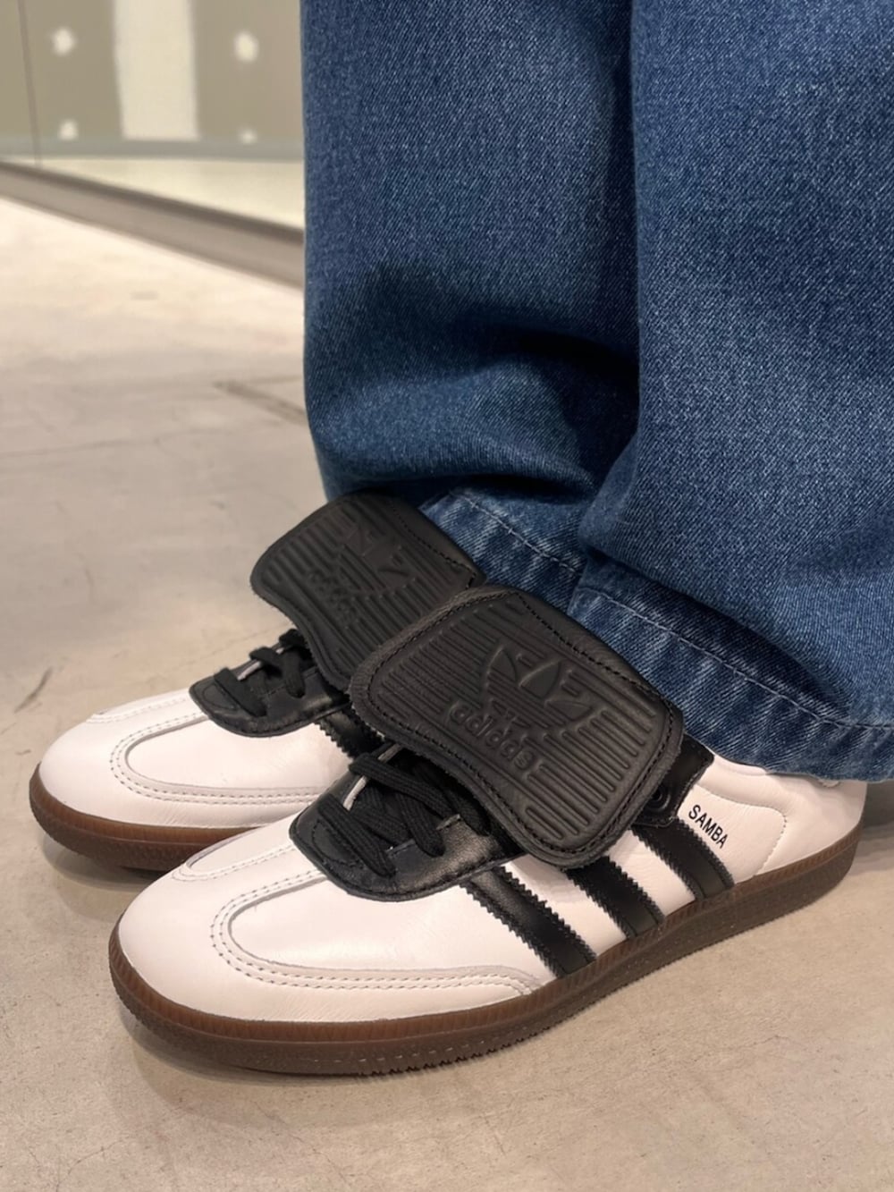 ブルー系のデニムジャケット、ブルー系のデニムパンツ、シルバー系のハンドバッグを着用したレディースの春コーディネートの2枚目の写真