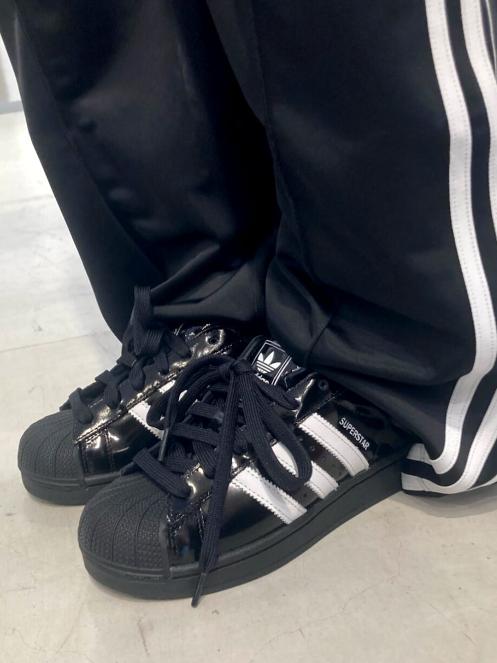 ブラック系のハンドバッグ、ブラック系のジャージ、ブラック系のスウェットパンツを着用したレディースの春コーディネートの2枚目の写真