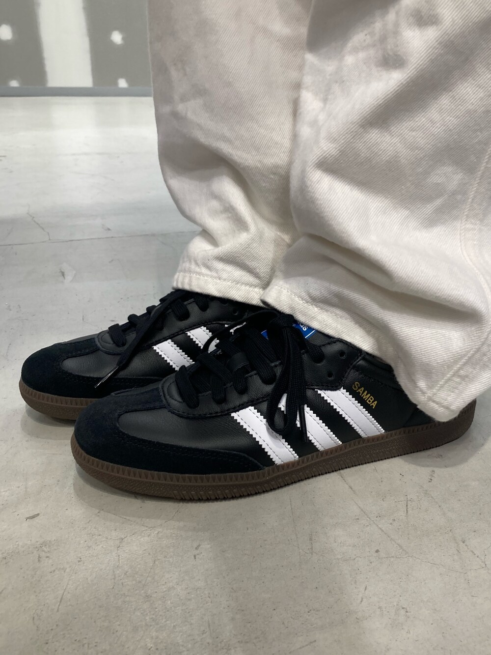 レッド系のスウェット、ブラック系のシューズを着用したレディースの春コーディネートの2枚目の写真