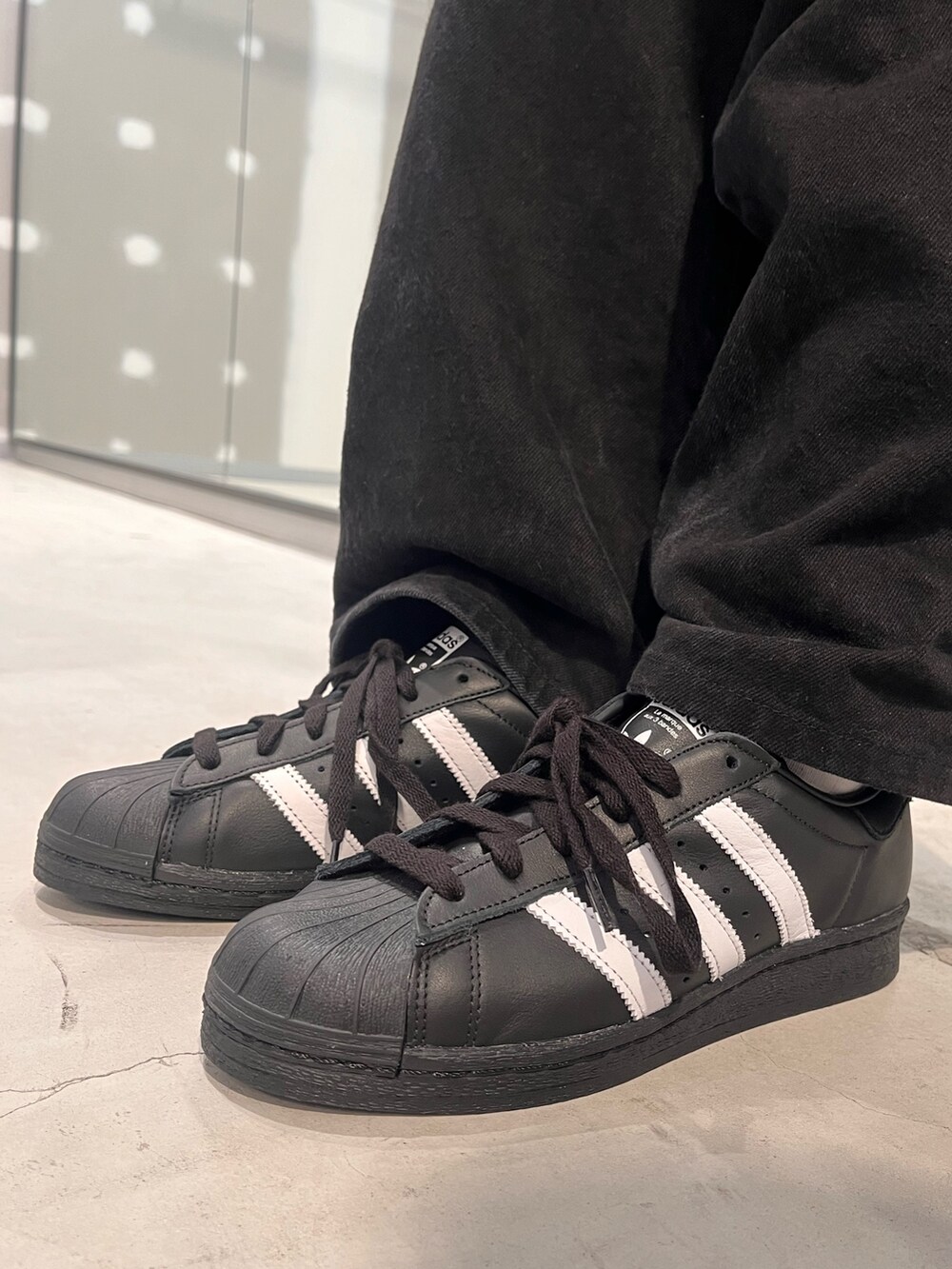 ブラック系のシューズ、ブラック系のバックパック/リュック、ブラウン系のパーカーを着用したレディースの冬コーディネートの4枚目の写真