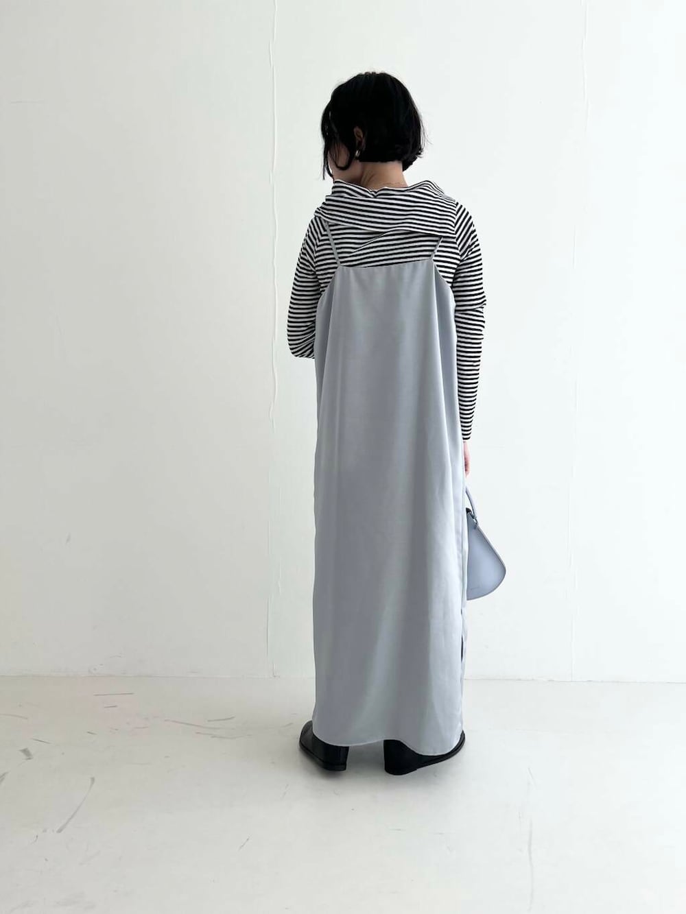 ブラック系のブーツ、ブルー系のワンピース、その他のTシャツ/カットソーを着用したレディースの秋コーディネートの3枚目の写真