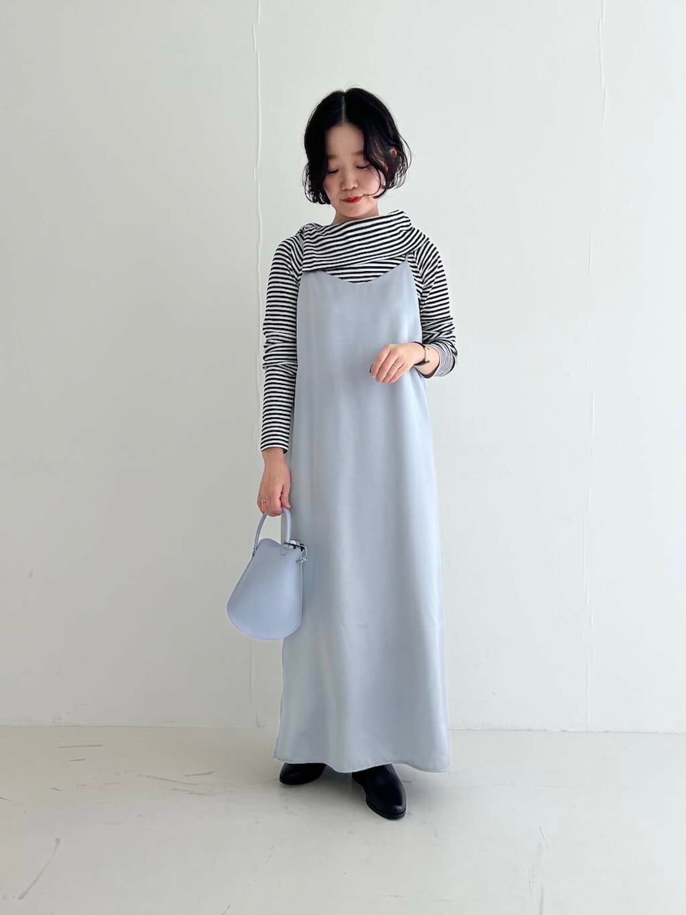 ブラック系のブーツ、ブルー系のワンピース、その他のTシャツ/カットソーを着用したレディースの秋コーディネートの2枚目の写真