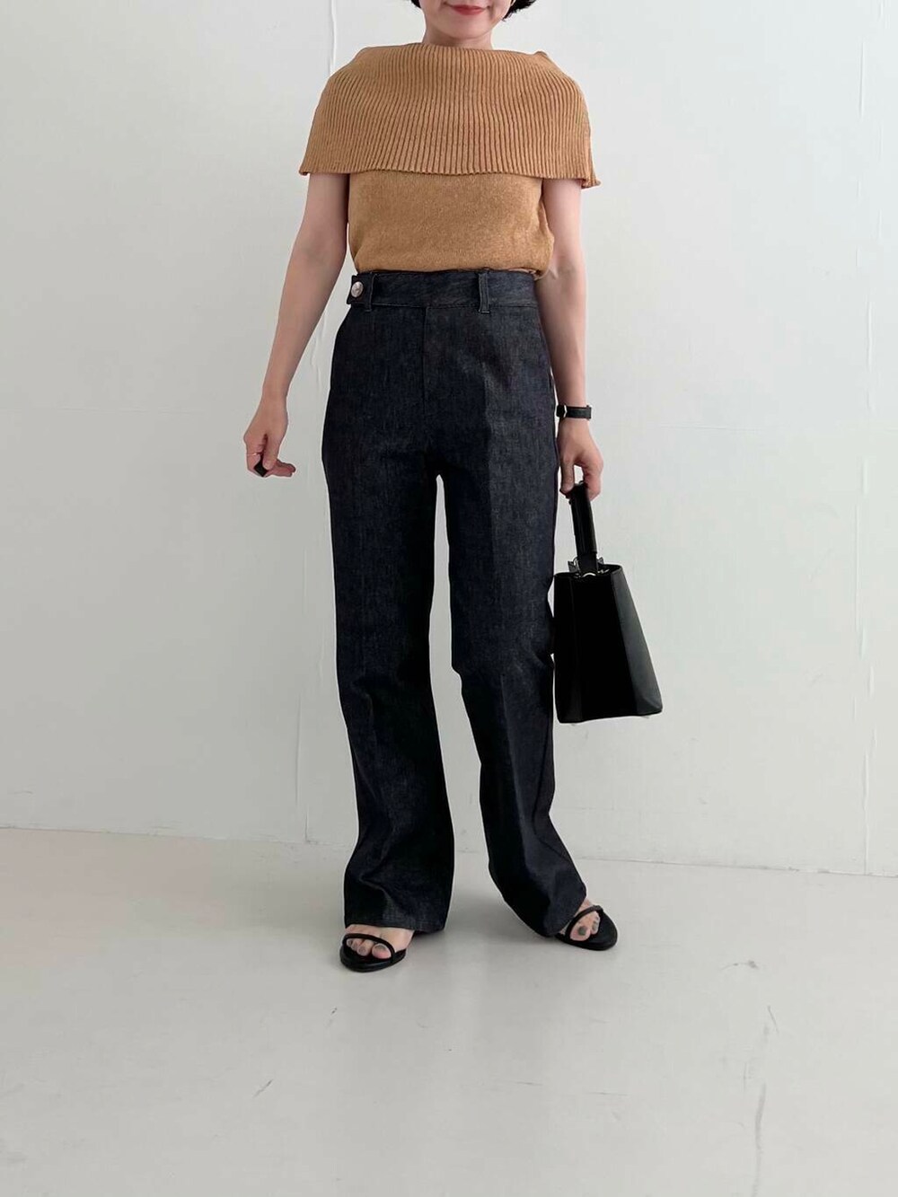 ブラック系のサンダル、ブルー系のデニムパンツ、イエロー系のニット/セーターを着用したレディースの夏コーディネートの3枚目の写真