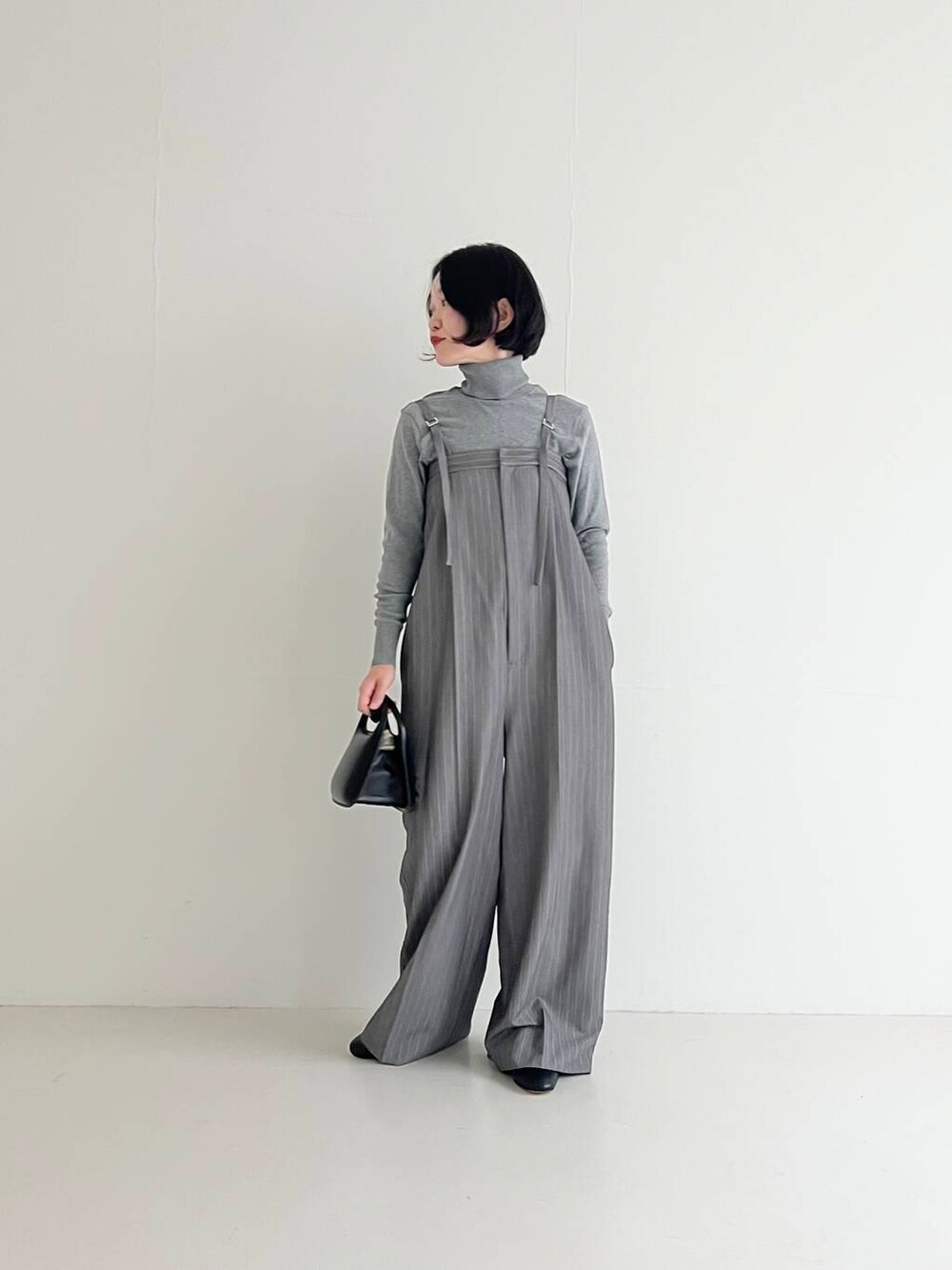 グレー系のサロペット/オーバーオール、ブラック系のハンドバッグを着用したレディースの夏コーディネートの2枚目の写真