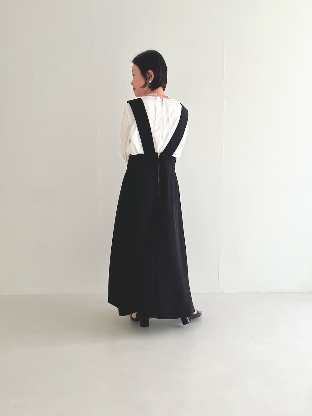 ブラック系のスカート、ホワイト系のシャツ/ブラウス、グレー系のハンドバッグを着用したレディースの冬コーディネートの5枚目の写真