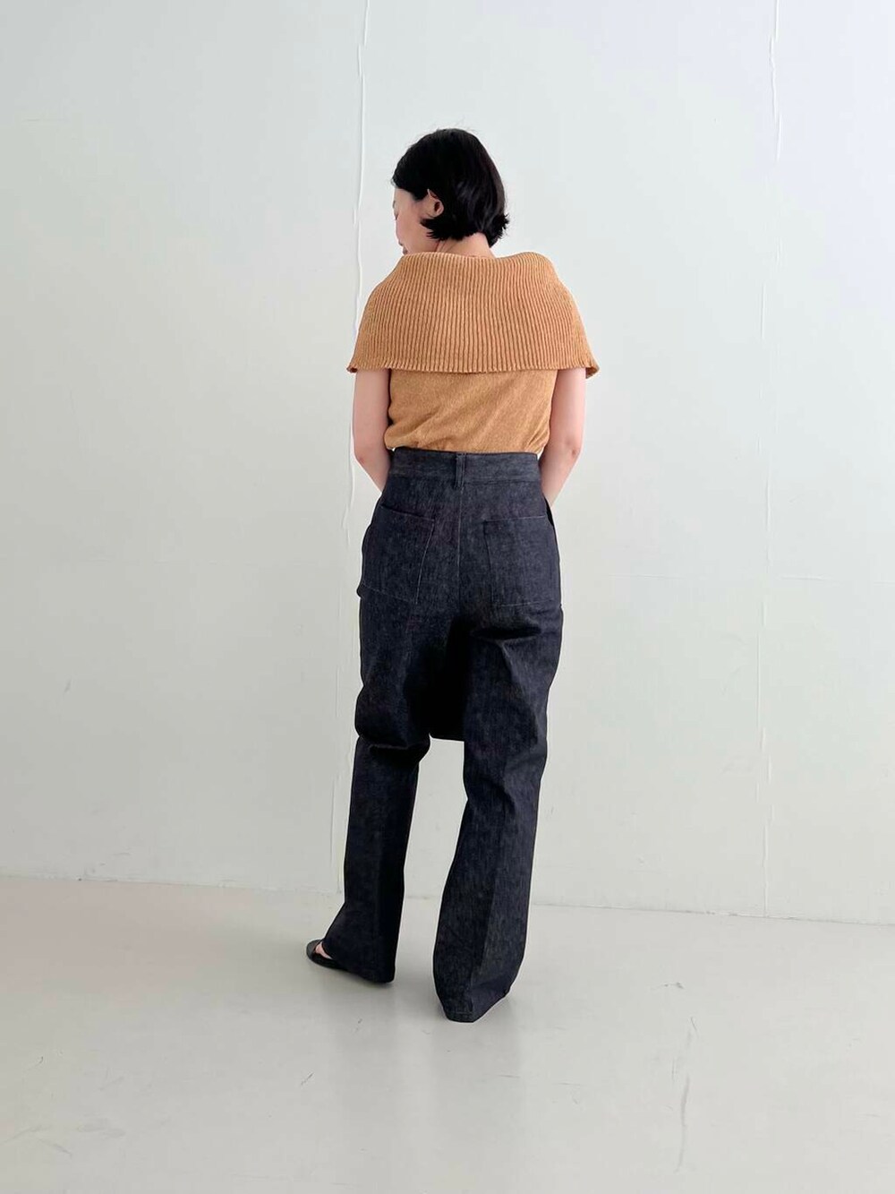 ブラック系のサンダル、ブルー系のデニムパンツ、イエロー系のニット/セーターを着用したレディースの夏コーディネートの5枚目の写真