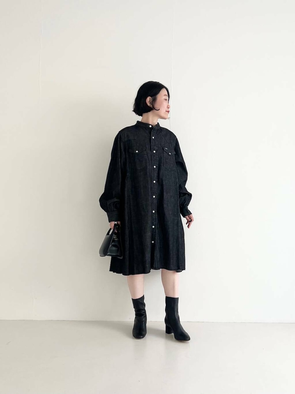 ブラック系のワンピース、ブラック系のハンドバッグを着用したレディースの夏コーディネートの3枚目の写真