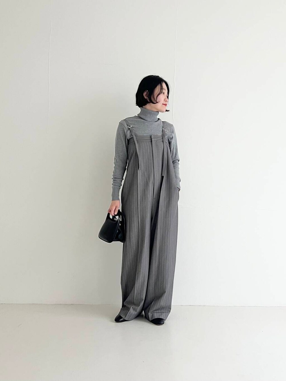 グレー系のサロペット/オーバーオール、ブラック系のハンドバッグを着用したレディースの夏コーディネートの4枚目の写真