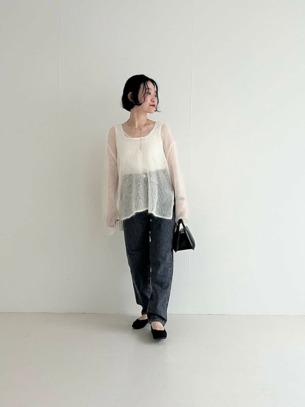 ホワイト系のタンクトップ、ブラック系のバレエシューズ、グレー系のデニムパンツを着用したレディースの夏コーディネートの6枚目の写真