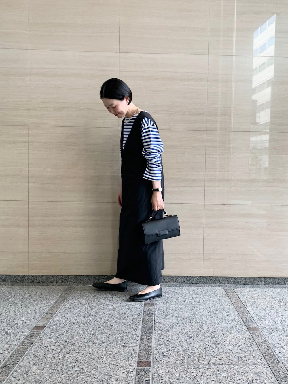 ブルー系のTシャツ/カットソー、ブラック系のワンピース、ブラック系のパンプスを着用したレディースの秋コーディネートの2枚目の写真