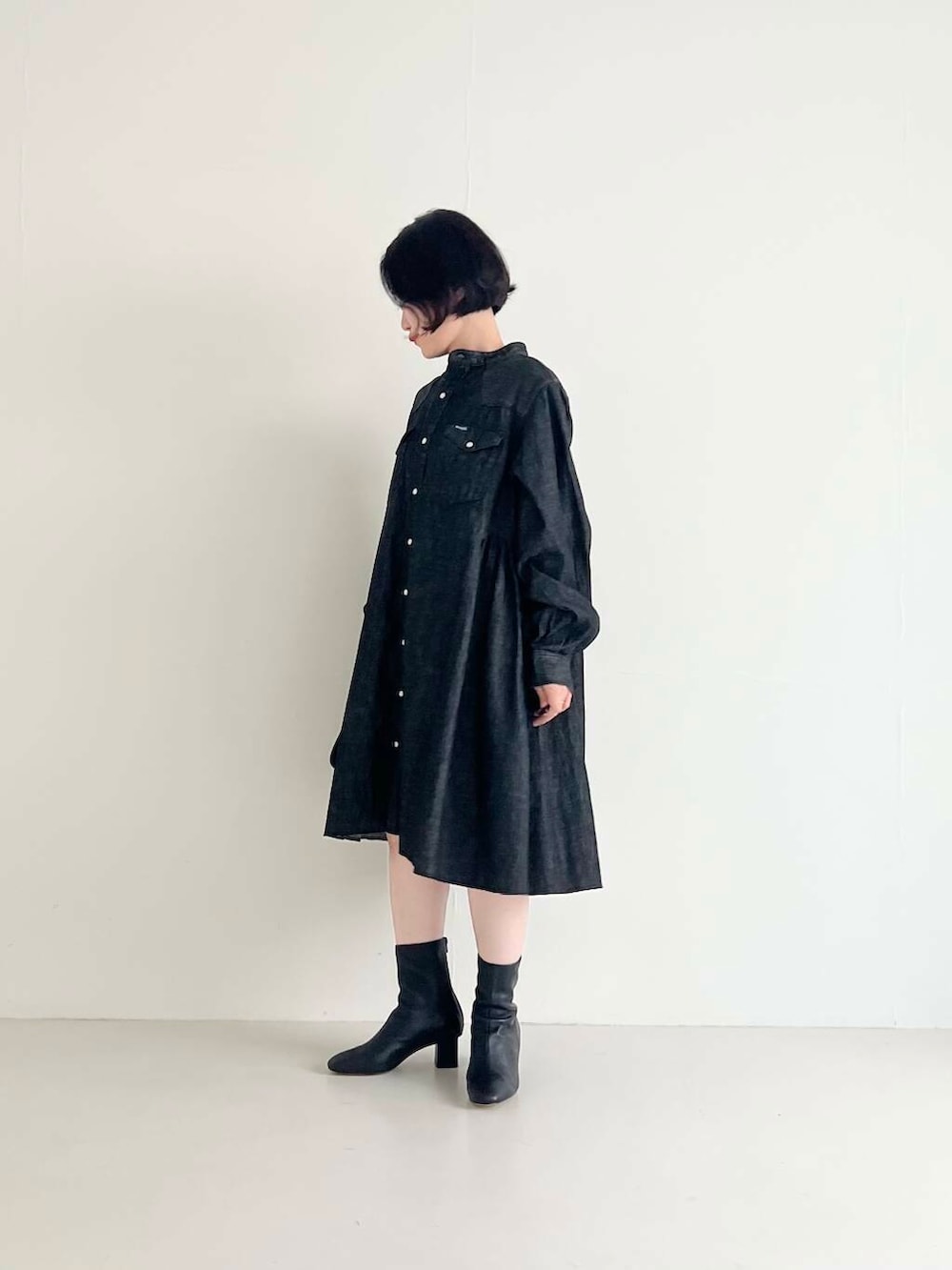 ブラック系のワンピース、ブラック系のハンドバッグを着用したレディースの夏コーディネートの2枚目の写真