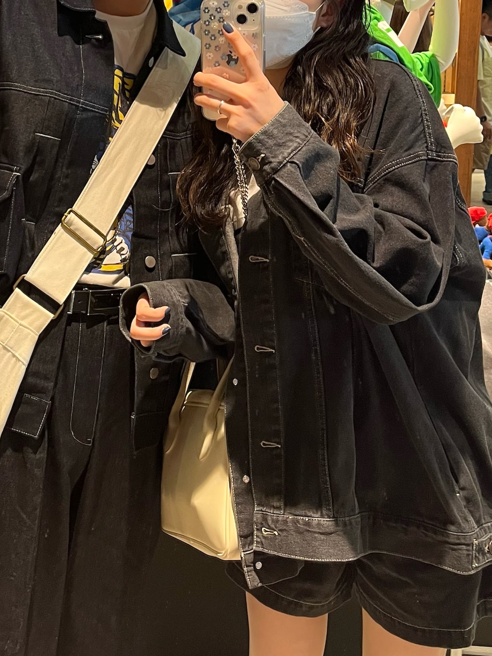 ブラック系のデニムジャケット、ホワイト系のTシャツ/カットソー、ブラック系のデニムパンツを着用したレディースの春コーディネートの3枚目の写真