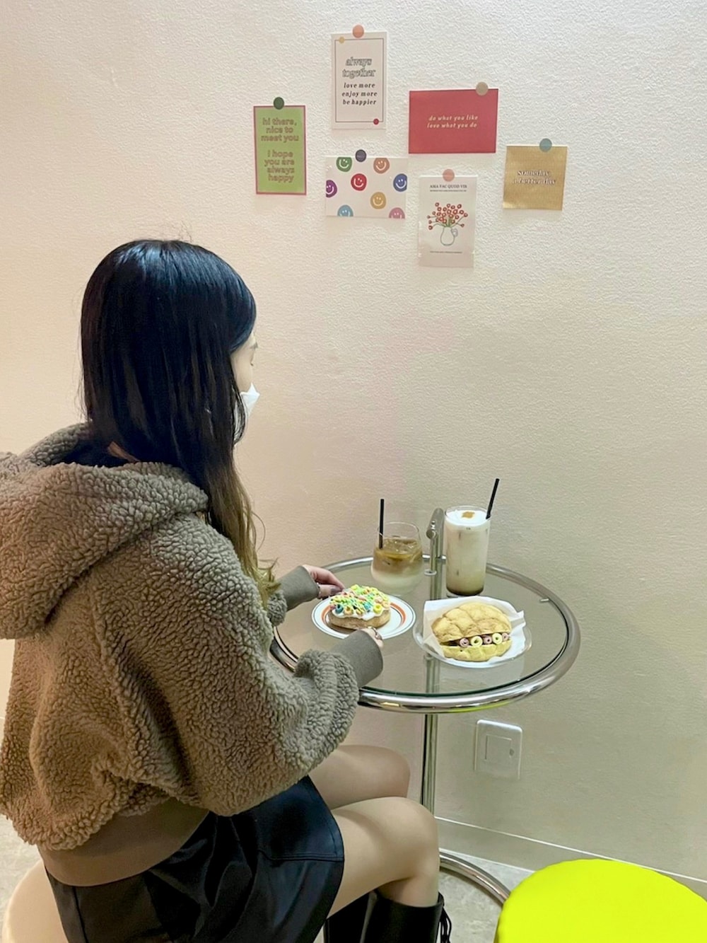 ブラウン系のパーカー、ブラック系のブーツ、ブラック系のスカートを着用したレディースの冬コーディネートの3枚目の写真