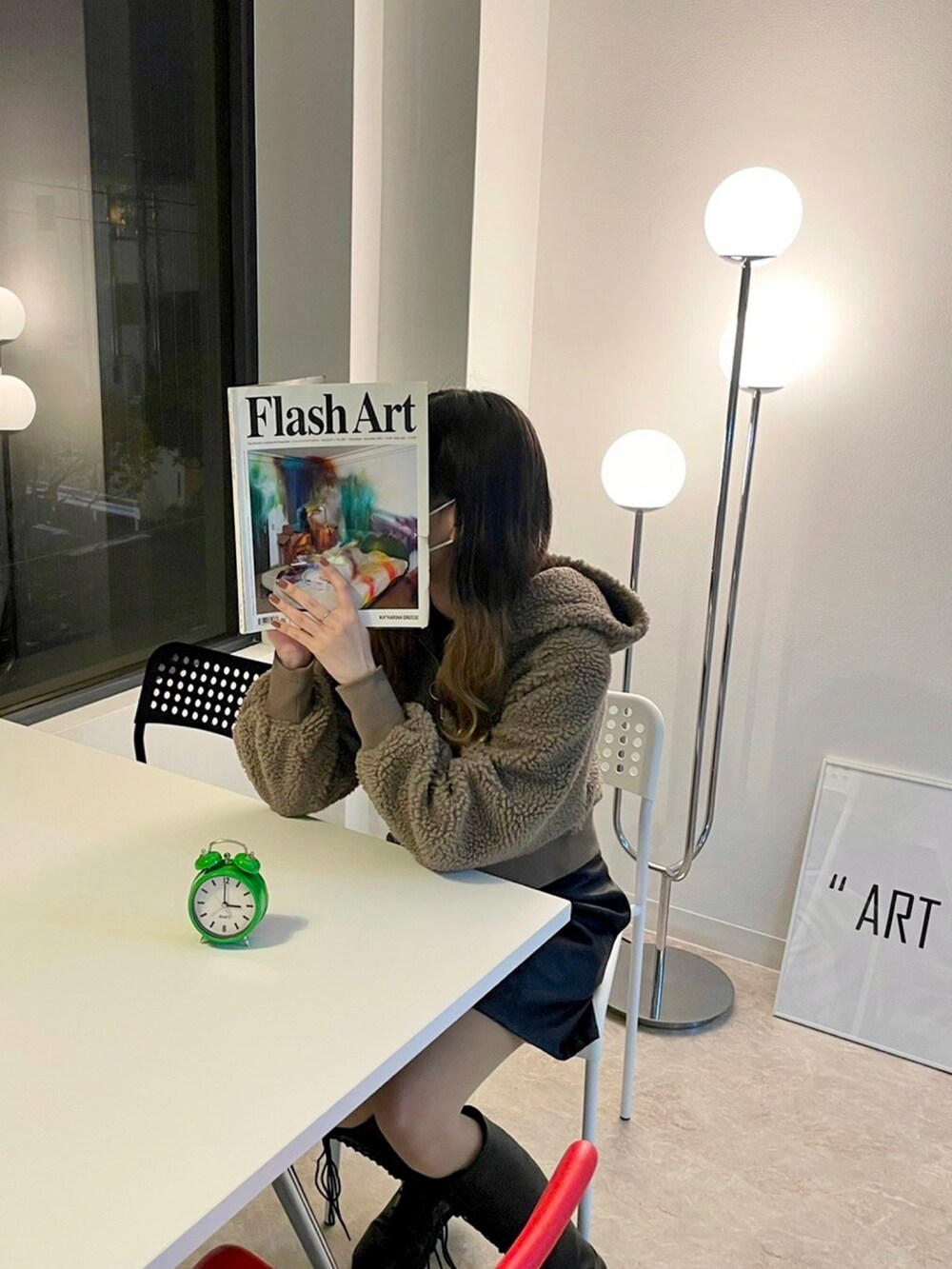 ブラウン系のパーカー、ブラック系のブーツ、ブラック系のスカートを着用したレディースの冬コーディネートの2枚目の写真