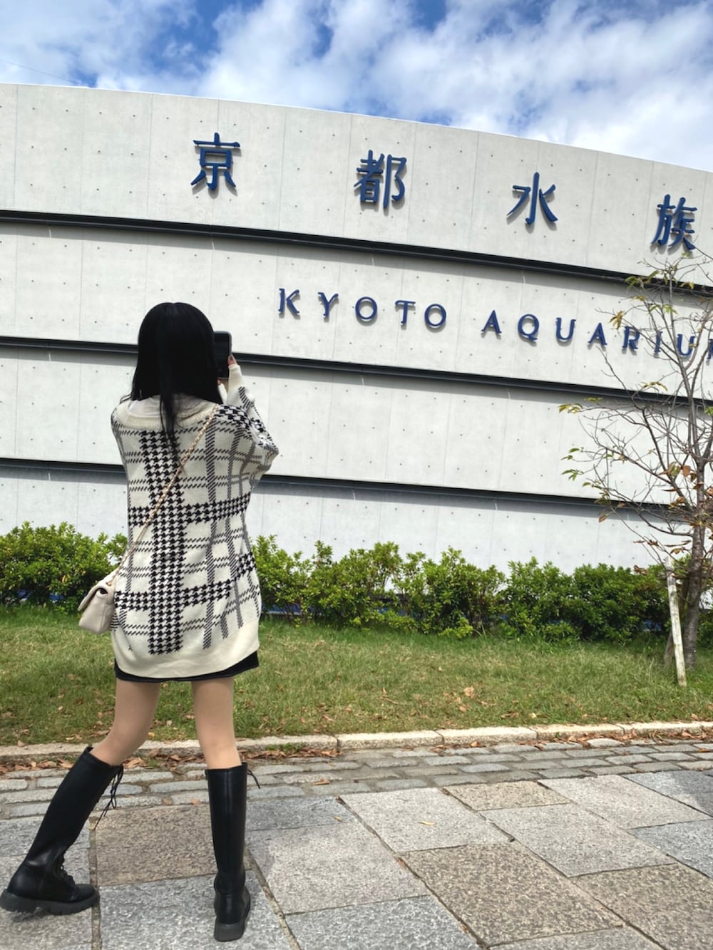 ブラック系のブーツ、ブラック系のスカート、ホワイト系のカーディガン/ボレロを着用したレディースの秋コーディネートの3枚目の写真