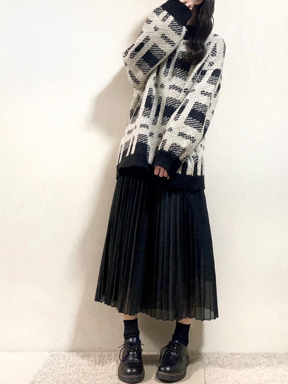 ベージュ系のステンカラーコート、ブラック系のニット/セーター、ブラック系のシャツ/ブラウスを着用したレディースの冬コーディネートの3枚目の写真