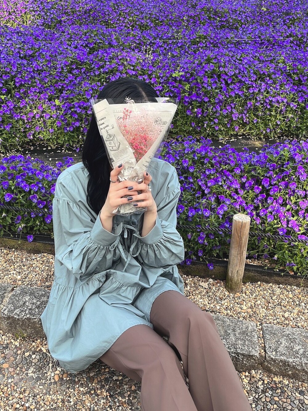 ブルー系のチュニック、ブラウン系のスラックスを着用したレディースの春コーディネートの2枚目の写真