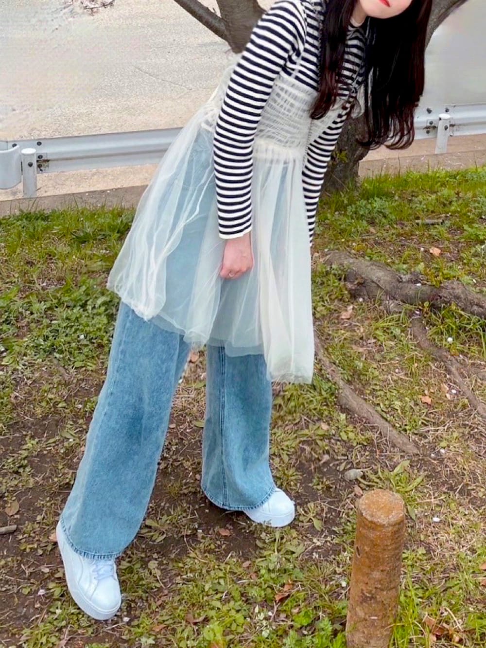 ホワイト系のワンピース、ブルー系のデニムパンツを着用したレディースの春コーディネートの2枚目の写真